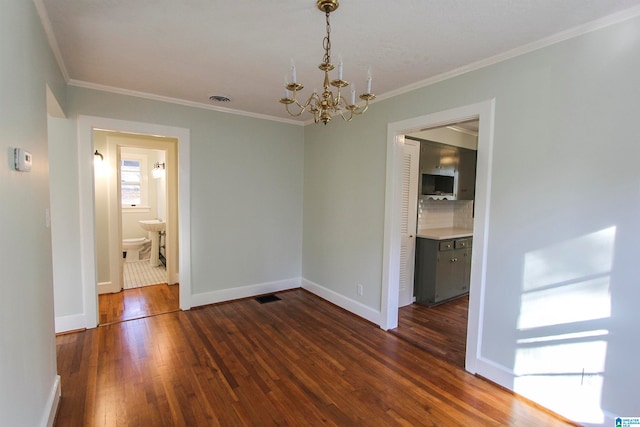 unfurnished room featuring dark hardwood / wood-style flooring, a notable chandelier, and ornamental molding