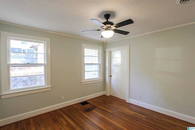 empty room with ceiling fan, dark hardwood / wood-style flooring, a textured ceiling, and ornamental molding