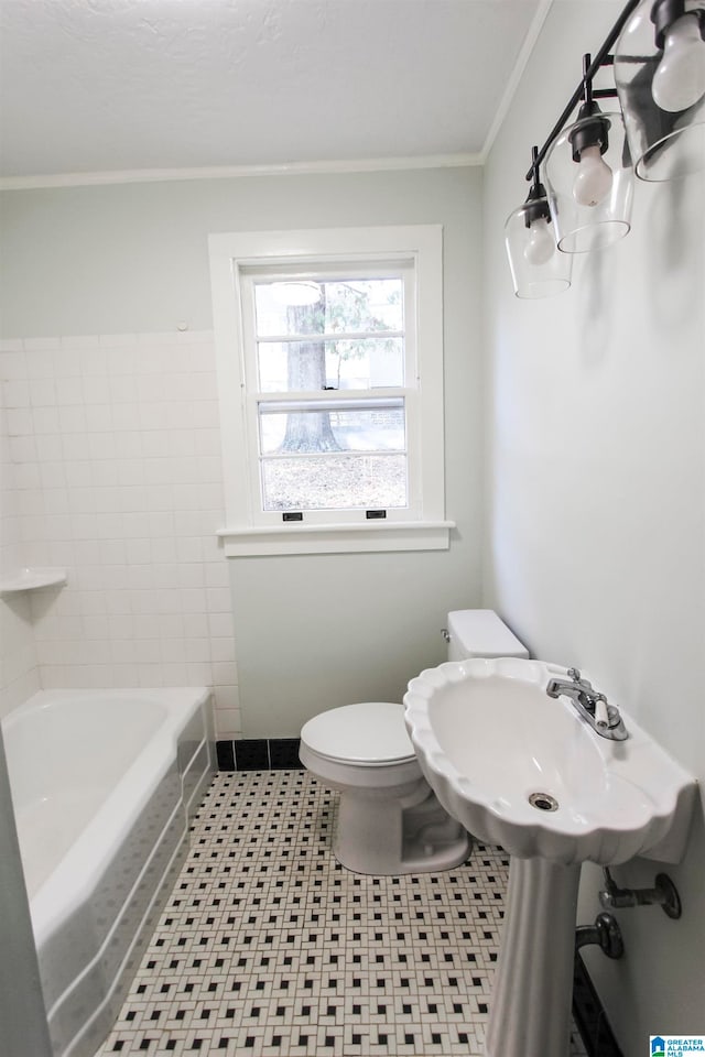 bathroom with toilet, tile patterned flooring, crown molding, and a bathing tub