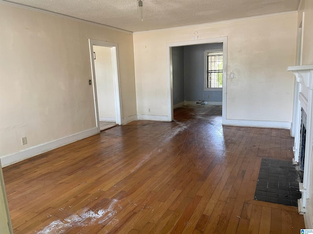 unfurnished living room with a textured ceiling and dark hardwood / wood-style floors