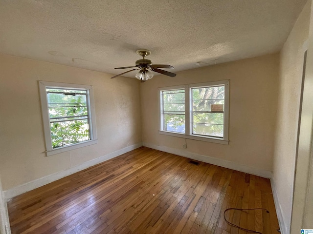 spare room featuring ceiling fan, wood-type flooring, and a textured ceiling