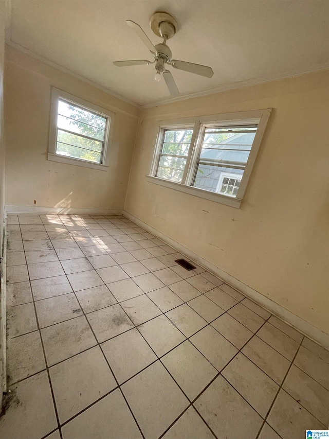 unfurnished room featuring plenty of natural light, ornamental molding, and light tile patterned floors