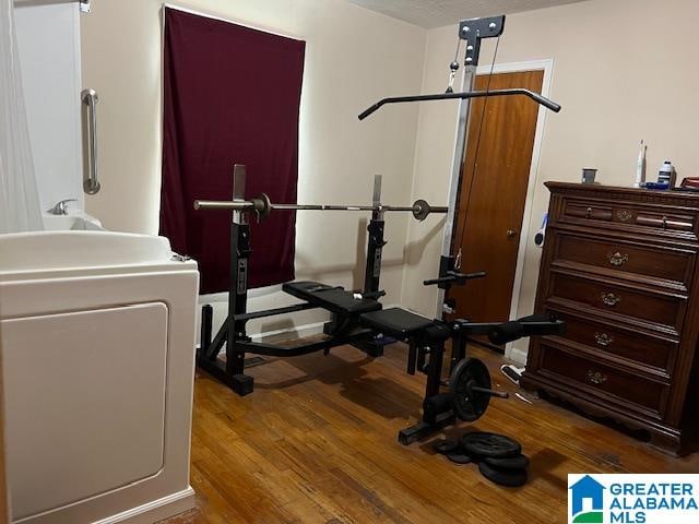 workout room with washer / dryer and hardwood / wood-style floors