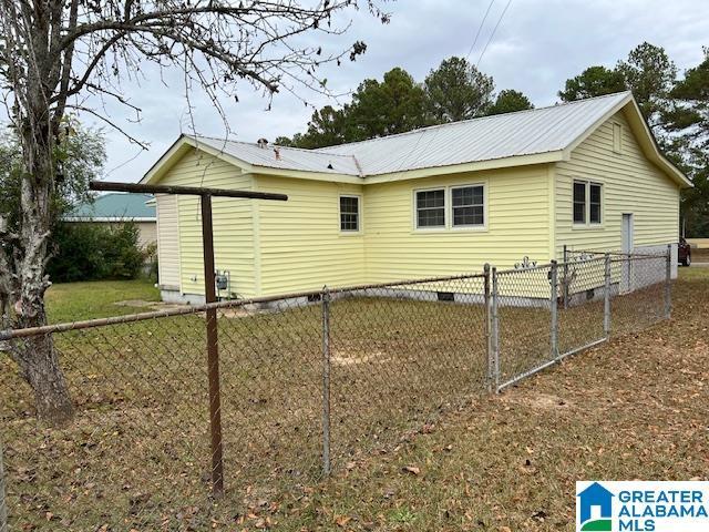928 Horne Dr, Talladega, AL 35160 - view of side of home with crawl space, fence, and metal roof
