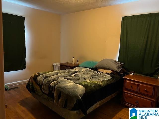 bedroom featuring hardwood / wood-style flooring and a textured ceiling