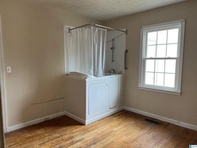 928 Horne Dr, Talladega, AL 35160 - full bathroom with wood finished floors, baseboards, healthy amount of natural light, and a textured ceiling