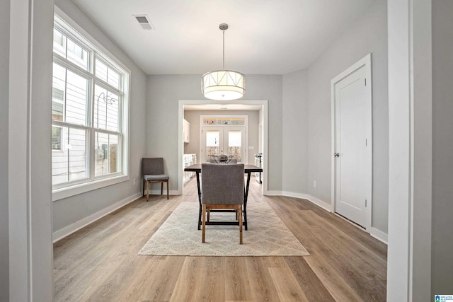 dining room with french doors and light hardwood / wood-style flooring