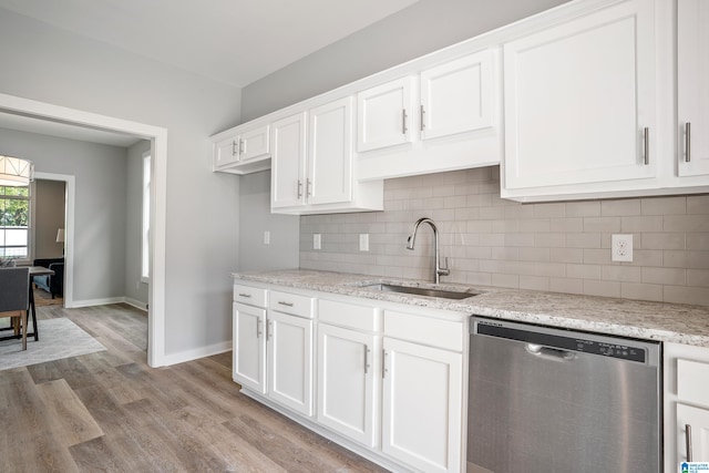 kitchen with white cabinetry, sink, light stone counters, stainless steel dishwasher, and light wood-type flooring