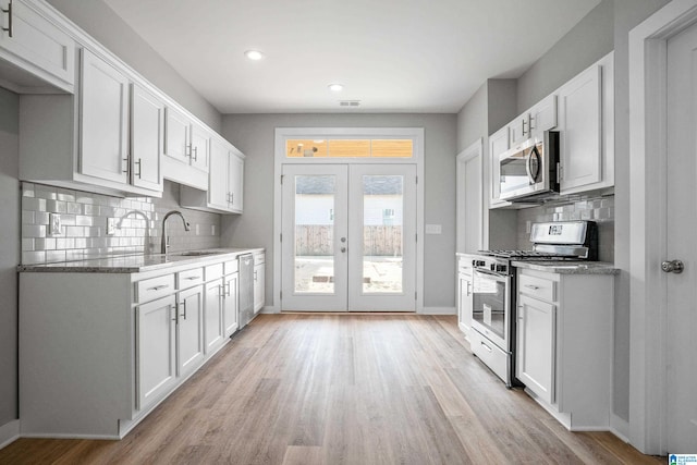 kitchen with french doors, stainless steel appliances, and white cabinetry