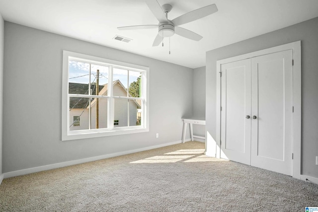 unfurnished bedroom featuring ceiling fan, a closet, and carpet