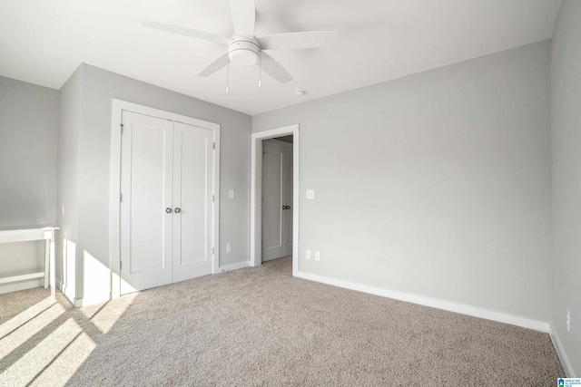 unfurnished bedroom with ceiling fan, a closet, and light colored carpet