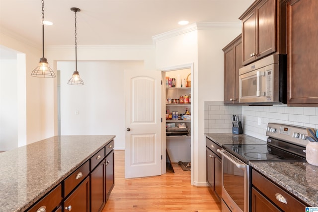 kitchen with decorative light fixtures, light wood-type flooring, stainless steel appliances, and dark stone countertops