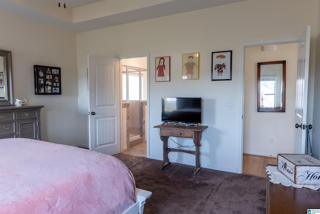 bedroom featuring dark colored carpet and connected bathroom