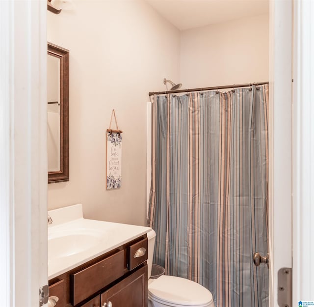 bathroom featuring vanity, toilet, and walk in shower