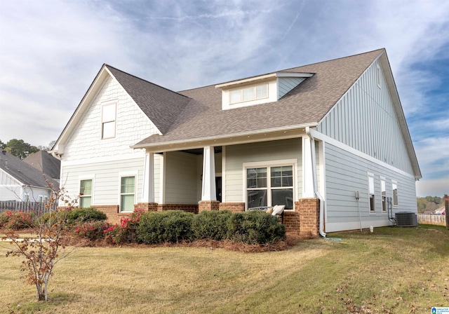 view of front of home with central air condition unit and a front lawn