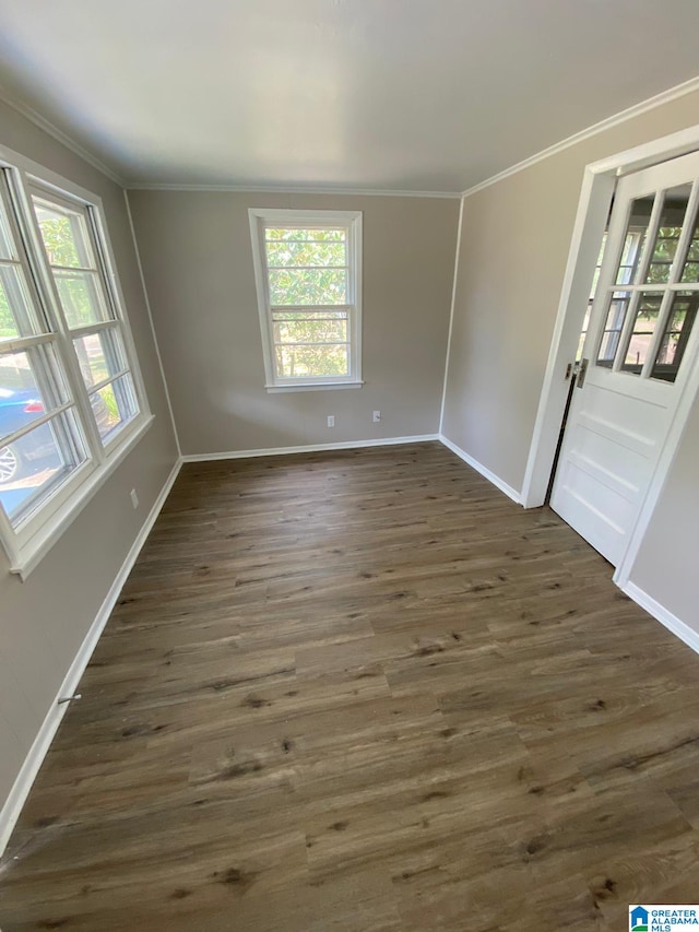 unfurnished room with ornamental molding and dark wood-type flooring