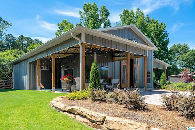 back of property featuring a yard and an outdoor structure