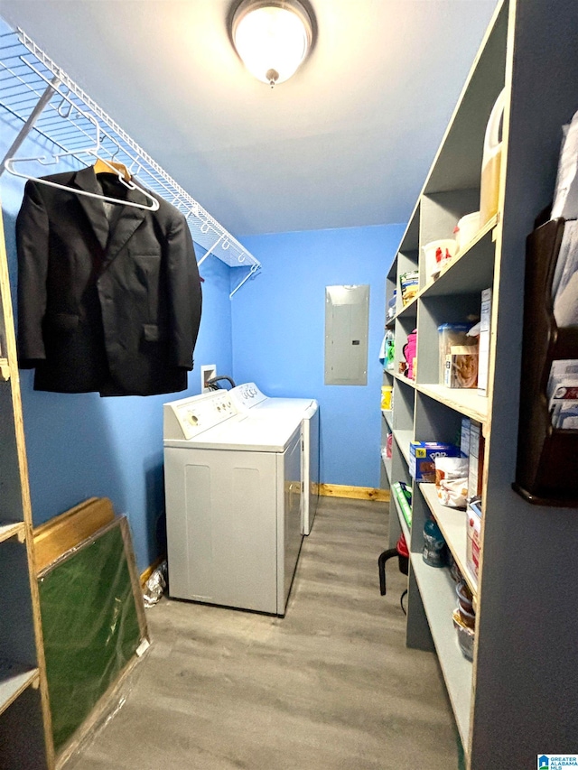 washroom with washing machine and dryer, light hardwood / wood-style floors, and electric panel