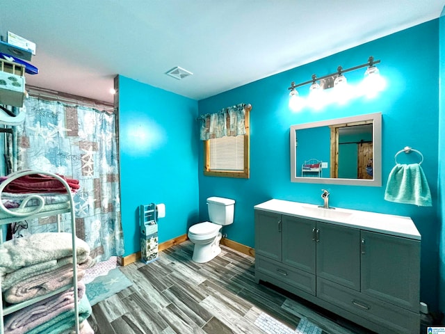 bathroom with hardwood / wood-style floors, vanity, toilet, and a shower with shower curtain