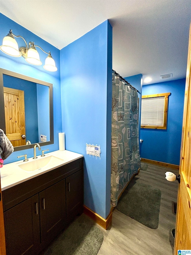 bathroom featuring hardwood / wood-style floors, vanity, and walk in shower