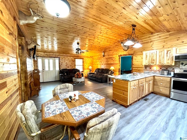 kitchen with stainless steel range with electric cooktop, wooden walls, vaulted ceiling, wood-type flooring, and extractor fan