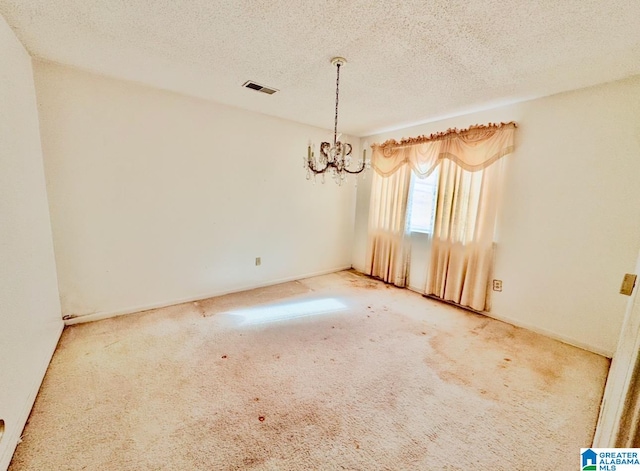 spare room featuring carpet and a textured ceiling