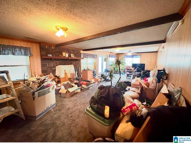 miscellaneous room with carpet, a textured ceiling, ceiling fan, beamed ceiling, and wood walls