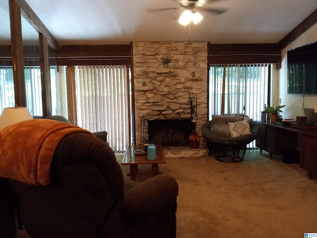 living room featuring a stone fireplace, ceiling fan, and carpet floors