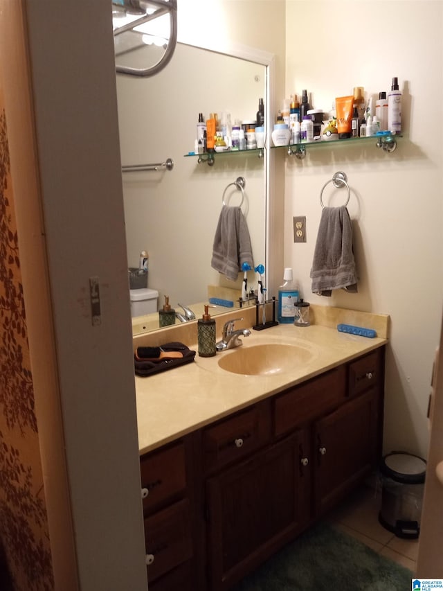 bathroom with tile patterned flooring, vanity, and toilet