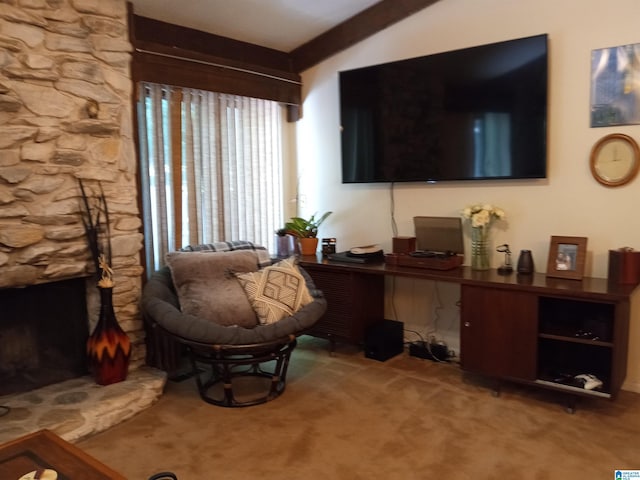 living area featuring carpet flooring, a stone fireplace, and vaulted ceiling