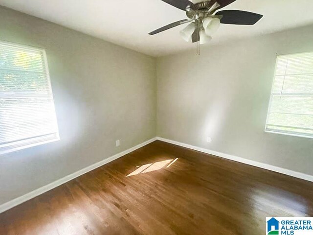 spare room with plenty of natural light, dark hardwood / wood-style floors, and ceiling fan