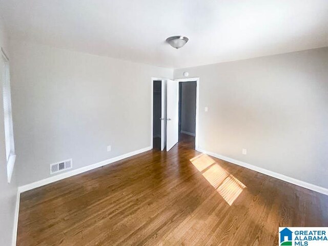 empty room with dark hardwood / wood-style flooring