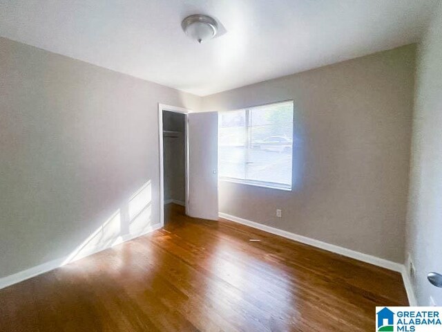 unfurnished bedroom with dark wood-type flooring and a closet