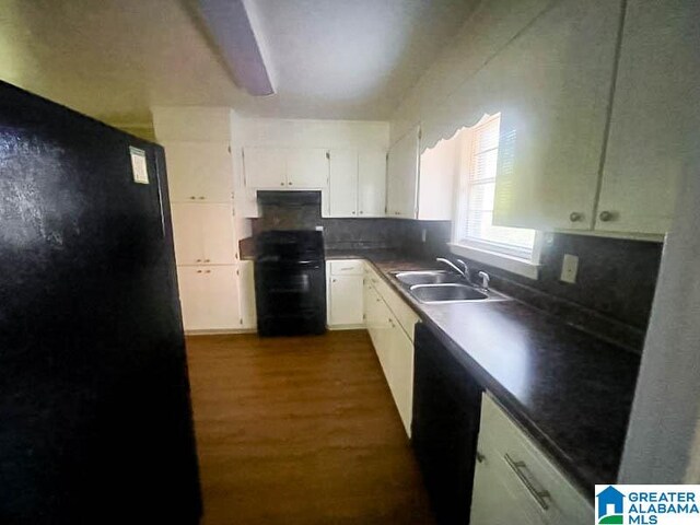 kitchen featuring sink, tasteful backsplash, dark hardwood / wood-style floors, white cabinets, and black appliances