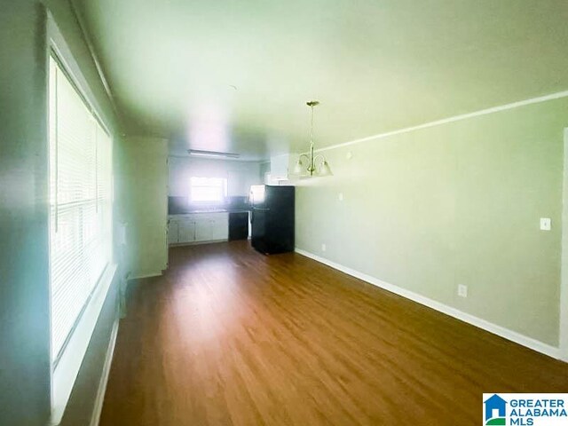 unfurnished room featuring dark hardwood / wood-style flooring and a chandelier