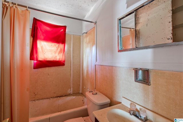 full bathroom with shower / bathtub combination with curtain, vanity, a textured ceiling, and toilet