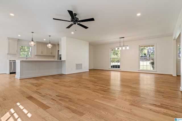 unfurnished living room with light hardwood / wood-style floors, ceiling fan, and sink