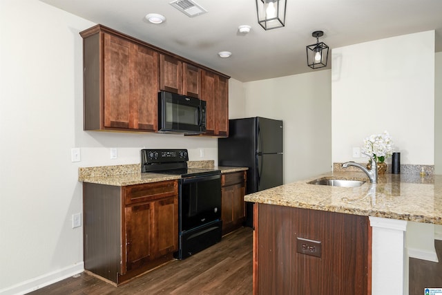 kitchen with light stone countertops, kitchen peninsula, sink, black appliances, and dark hardwood / wood-style floors