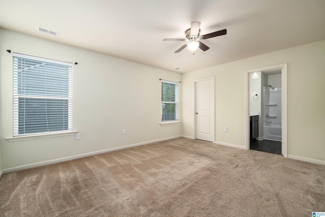 unfurnished bedroom featuring carpet flooring, ensuite bath, and ceiling fan