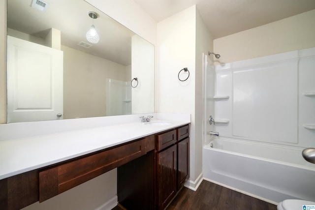 bathroom featuring washtub / shower combination, hardwood / wood-style floors, and vanity