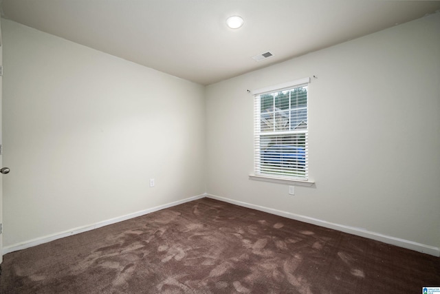 unfurnished room with dark colored carpet