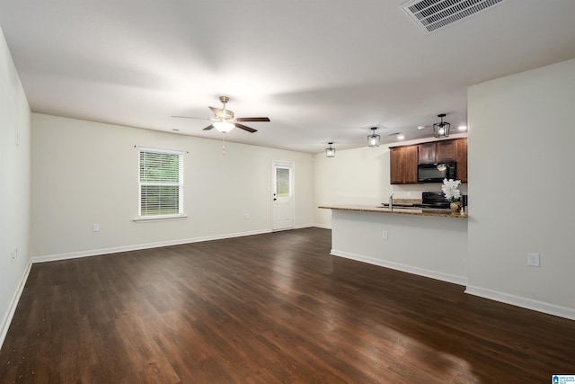 unfurnished living room with ceiling fan, sink, and dark wood-type flooring