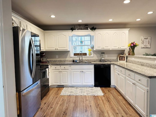 kitchen featuring light stone countertops, white cabinetry, sink, light hardwood / wood-style flooring, and black appliances