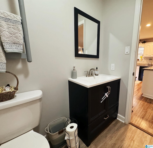 bathroom featuring hardwood / wood-style floors, vanity, and toilet