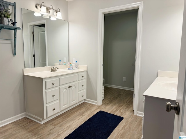 bathroom featuring wood-type flooring, vanity, and toilet