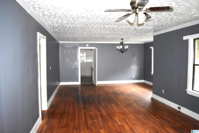 unfurnished room featuring crown molding, ceiling fan with notable chandelier, dark wood-type flooring, and a textured ceiling