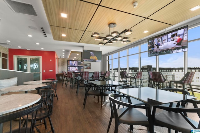 dining space with dark hardwood / wood-style flooring and wood ceiling