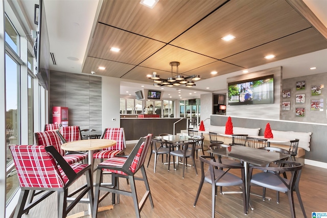 dining area featuring a chandelier, wood ceiling, and light hardwood / wood-style flooring