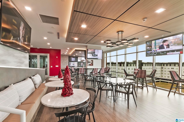 dining space featuring wood-type flooring, expansive windows, ceiling fan, and wood ceiling