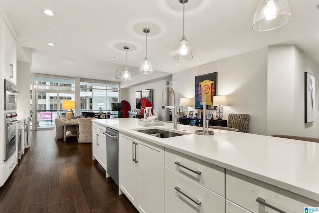 kitchen featuring dishwasher, sink, dark hardwood / wood-style flooring, decorative light fixtures, and white cabinets